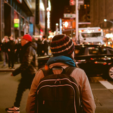 Ein junge Frau geht unglücklich im Ausland durch eine Stadt